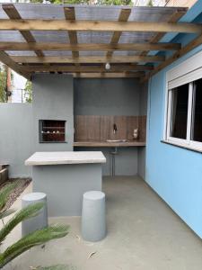 Una cocina al aire libre con encimera y techo de madera. en Casa 2 dormitórios, en Passo de Torres 8 fotos más