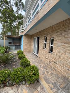 un edificio de ladrillo con una pasarela de piedra delante de él en Casa 2 dormitórios, en Passo de Torres