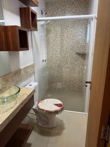 Un baño con ducha, inodoro y lavabo. en Casa 2 dormitórios, en Passo de Torres
