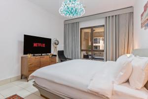 a bedroom with a bed and a tv and a chandelier at Downtown Zaafaran 2, in Dubai +43 photos