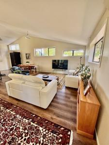 a living room with a couch and a table at Pauanui Orchard Farmstay - Pet Friendly! in Hikuai