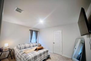 a bedroom with a bed and a flat screen tv at Private Cozy Rooms and Bathroom in Home near Seaworld Riverwalk and AFB in San Antonio