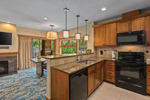 a kitchen with wooden cabinets and a stove top oven at WorldMark Chelan - Lake House in Chelan