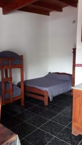 a small bedroom with a bed and a chair at Complejo Junior in San Clemente del Tuyu