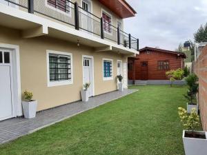 a house with a green lawn in front of it at Complejo Junior in San Clemente del Tuyu