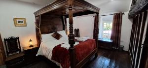 a bedroom with a four poster bed in a room at 2 Double Bed Cottage Hottub Lake District Keswick in Keswick