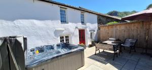 a bath tub on a patio next to a house at 2 Double Bed Cottage Hottub Lake District Keswick in Keswick +26 photos