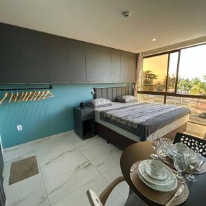 a bedroom with a bed and a table with chairs at Flat com vista linda para o mar! in Cabedelo +33 photos