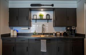 a kitchen with black cabinets and a sink at THE HAPPY PLACE in Newaygo