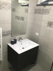 uma casa de banho com um lavatório branco e um espelho. em Appartamento Malabranca em Orvieto