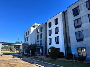a white building with a bridge in the background at Travelodge by Wyndham Flowood in Flowood