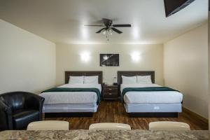 SteinbachSleep Suite Motel的酒店客房配有两张床和吊扇。