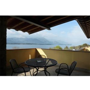 a balcony with a table and chairs and a view of the water at Residence Miralago Rooms & Apartments in Manerba del Garda