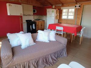 a living room with a couch and a kitchen with a table at Cabaña Los Cisnes in El Calafate