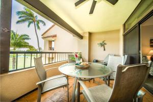 a balcony with a table and chairs and a view of the ocean at Kaanapali Royal B303 · KRL B303 Relaxing 2BD on Golf Course w Po in Lahaina