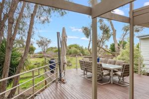 eine Terrasse mit Tisch und Stühlen auf einem Deck in der Unterkunft Private Access to Beach Oceanview with Home Gym in Cowes