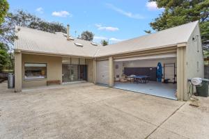 ein Haus mit einer Garage mit einer Tischtennisplatte in der Unterkunft Private Access to Beach Oceanview with Home Gym in Cowes