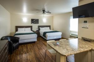 a hotel room with two beds and a kitchen at Sleep Suite Motel in Steinbach