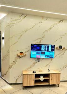 a wall with a tv on a marble wall at Le Havre de Paix in Nabeul