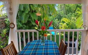 a table with a vase of flowers on a porch at Bungalow dans Résidence Fleurie in Saint-François