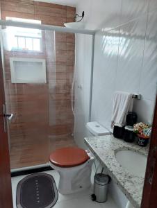 a bathroom with a shower with a toilet and a sink at Cantinho da família in Araruama