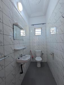 Un baño blanco con inodoro y lavabo. en Villa Ange Coeur, en Komé 35 fotos más