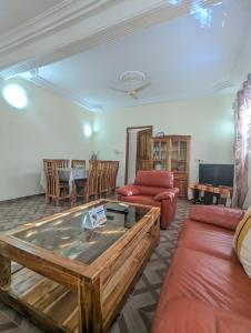 una sala de estar con un sofá y una mesa en Villa Ange Coeur, en Komé