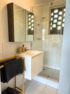 a bathroom with a sink and a shower at Renovated Cosy Stay Near CBD & StKilda with Pool & Sauna in Melbourne