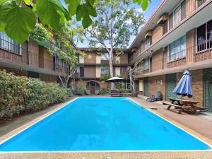 a large blue swimming pool in front of a building at Renovated Cosy Stay Near CBD & StKilda with Pool & Sauna in Melbourne