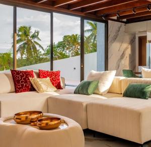 sala de estar con 2 sofás y ventanas en Luxury Oasis Porto de Galinhas, en Ipojuca