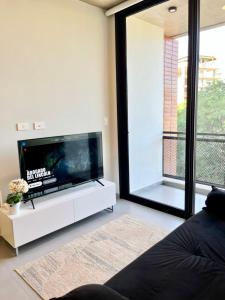 Una sala de estar con televisión y una gran ventana. en Edificio Venire, en Asunción