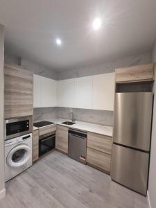 a kitchen with a stainless steel refrigerator and a dishwasher at Urban Suites Aluche in Madrid