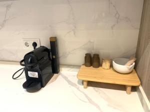 a black appliance sitting on a counter next to a table at Urban Suites Aluche in Madrid