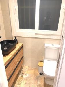 a bathroom with a black sink and a toilet at Urban Suites Aluche in Madrid