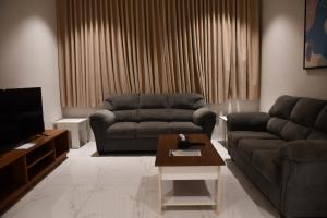 a living room with a couch and a coffee table at فندق جراند جرين in Jazan