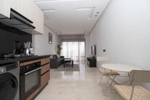 a kitchen and living room with a stove and a table at Bright Cozy Escape Walk to CFC Self Check-in in Oulad Akkou +39 photos