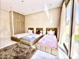 deux lits dans une chambre avec une fenêtre dans l'établissement Villa d eden , Private Pool and Hammam, à Azib Oulad Lâdem 16 autres photos