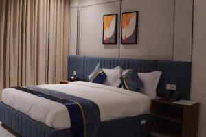 a bedroom with a large bed with a blue headboard at فندق جراند جرين in Jazan