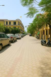 a street with cars parked on the side of the road at Premium Villa's Vrindavan in Vrindāvan +14 photos