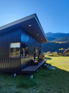 a blue house with a wooden deck on a field at Cabañas Saiko in Futaleufú