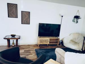 a living room with a tv and a couch and a table at The Study, a Summer Retreat in Corvallis