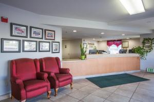 a waiting room with two red chairs and a counter at University Inn Fresno in Fresno