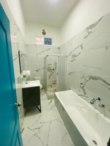 a white bathroom with a tub and a sink at Apartamento Ciudad del Surf Montañita in Montañita +27 photos