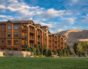a large apartment building with mountains in the background at WorldMark Chelan - Lake House in Chelan