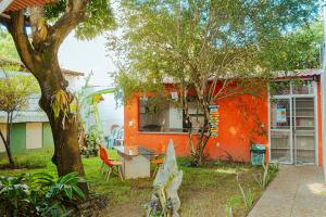 an orange house with a table and chairs in a yard at Chalé por do Sol in Aracaju
