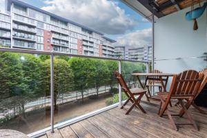 een balkon met 2 stoelen en een tafel op een gebouw bij Battersea Power Station Apartment in Londen