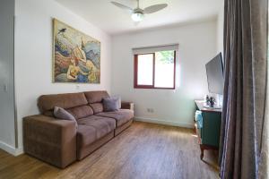 sala de estar con sofá marrón y TV en House with Beach Access - 2 min Walk, en Florianópolis