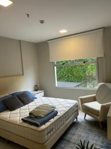 una camera da letto con un letto, una sedia e una finestra di Home Herrera ad Asunción