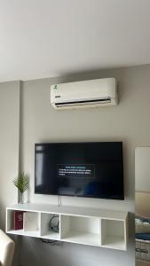 una TV a schermo piatto seduta su una mensola bianca di Home Herrera ad Asunción