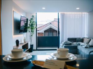 un salon avec un canapé et une table avec de la vaisselle dessus dans l'établissement Lunari Home, à Cuenca